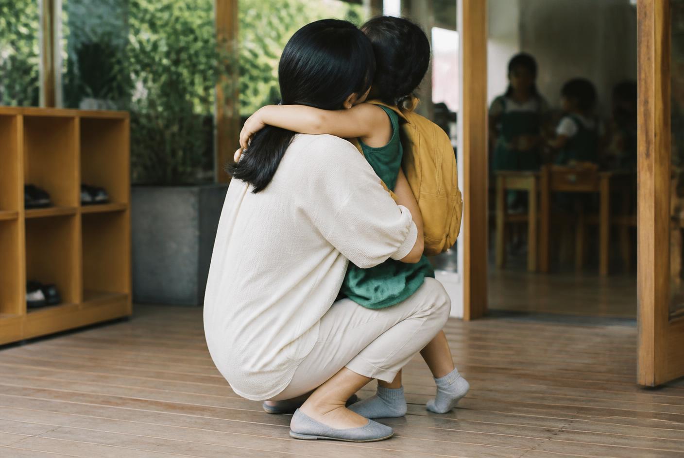 Una educadora recibe a una familia en la entrada de una escuela Nest!